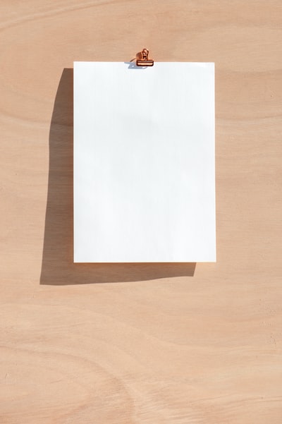 棕色木桌上的白色打印纸